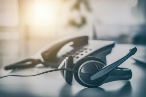 Communication support, call center and customer service help desk. VOIP headset on laptop computer keyboard.